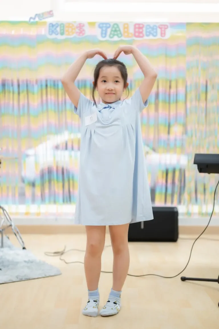 นักเรียนชุดฟ้าทำท่าหัวใจบนเวที Kids Talent