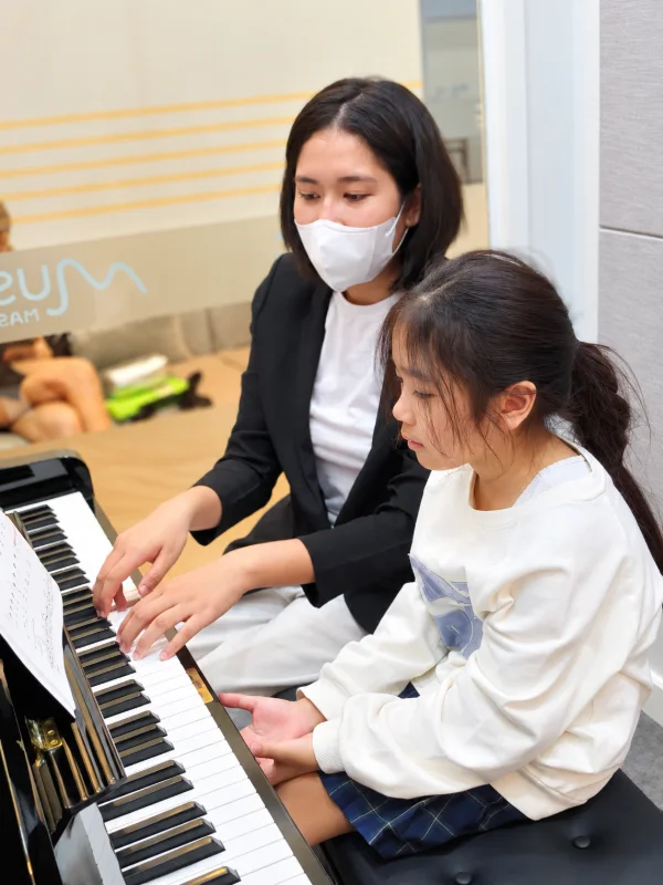 ครูเปียโนนั่งเล่นเปียโนคู่กับนักเรียน เรียนเปียโนที่ Music Mastery เกษตร-นวมินทร์
