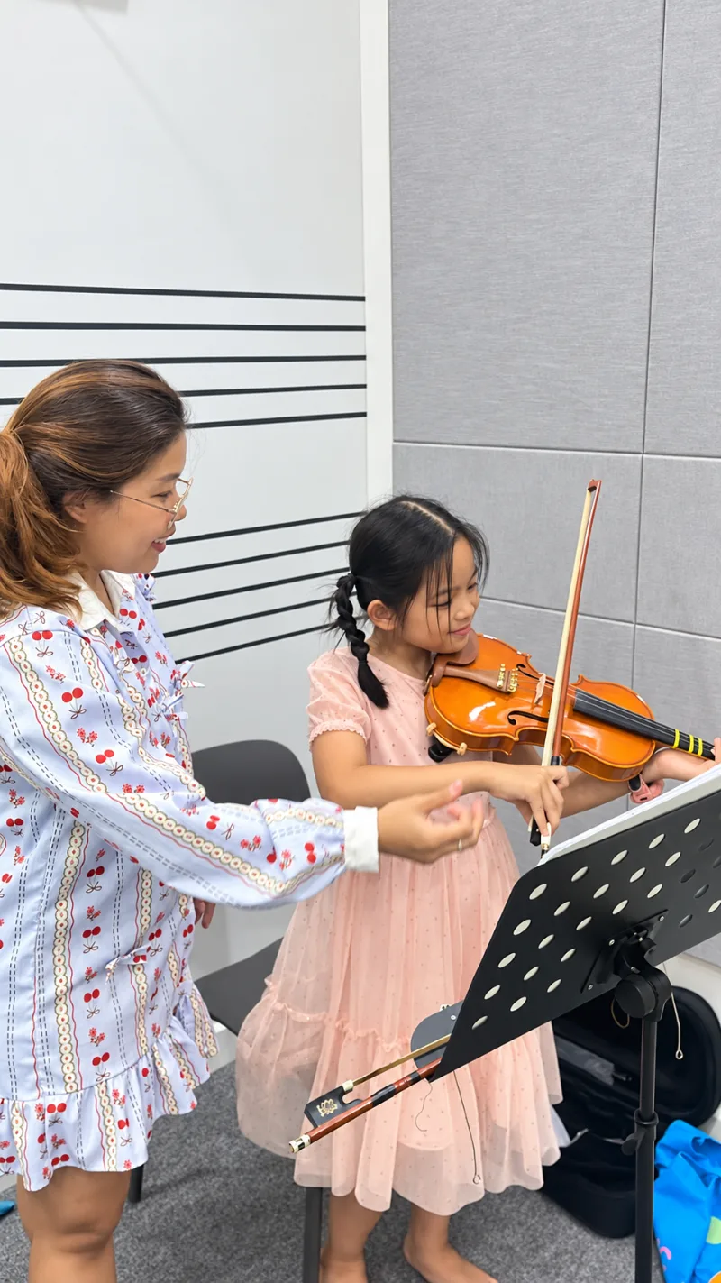 คุณครูสอนนักเรียนจับคันชักไวโอลินในห้องเรียนดนตรี Music Mastery
